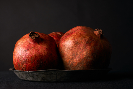 Fresh juicy pomegranate on black backgroundの写真素材