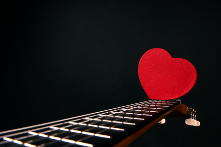 Valentines Day concept with red hearts on acoustic guitar isolated on black background with copy space for textの写真素材