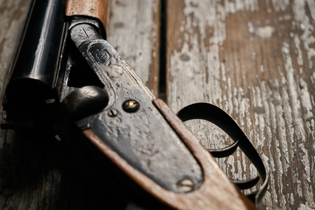 Hunting shotgun riffle on old rustic wooden table