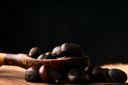 Roasted chestnuts in a wooden spoonの写真素材