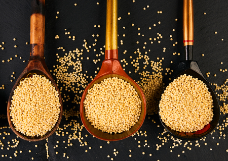 Millet seeds in wooden spoons