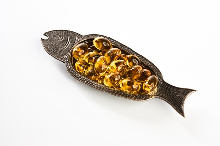 Fish oil pills close-up. Cod liver oil omega 3 gel capsules isolated on white background. Medical...