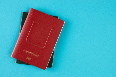 Passport travel document. Red, green and brown passports on blue background with copy space, view from above, top view, close-up. Travel conceptの写真素材