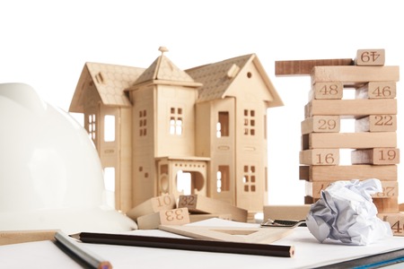 House model, wooden blocks, helmet and blueprint or architectural project isolated on white background. Planning, risk and strategy of project management in business. Business and construction conceptの写真素材
