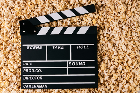 Movie clapper board and pop corn on background with copy space, top view. Movie time concept, close-upの写真素材