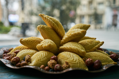 Traditional Azerbaijan pastries shekerbura for Novruz spring equinox celebration on tray on wooden table, close-upの写真素材