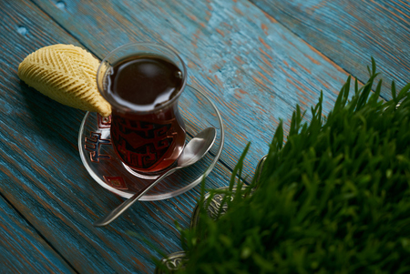 Shekerbura with nuts and honey. Novruz tray with Azerbaijan national pastry and glass of black tea on wooden table background, top view. Delicious dessert holiday food shekerburaの写真素材
