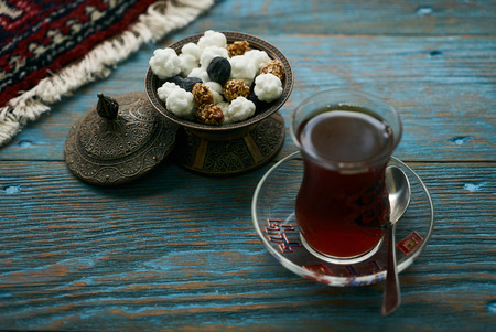 Novruz holiday with Azerbaijan national pastry Gogal and glass of black tea on rustic wooden table...