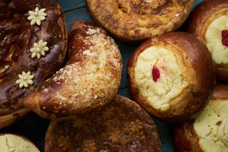 Traditional Russian Easter baked goods, kulichi, patties with cottage cheese, karavai and loaf cake with nuts on festive table backgroundの写真素材