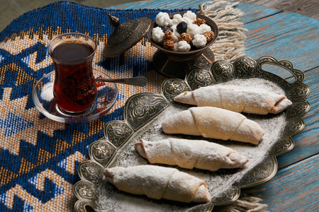 Homemade Mutaki roll cake with walnuts and sugar powder, oriental sweets mutaki pastry and...