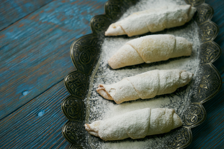 Biscuits with walnuts and sugar powder, oriental sweets mutaki pastry on rustic wooden blue table background, close-upの写真素材