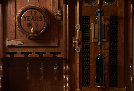 Vintage old wine barrel cabinet with bottle of red wine, close-upの写真素材