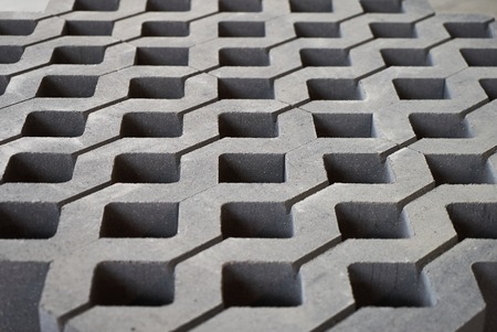 Lawn tile in cement factory. sidewalk square tiles. The Cement brick between green grass.