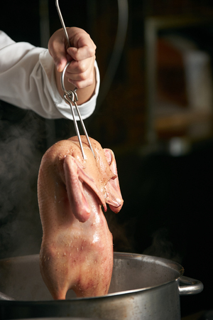 Chef is cooking beijing duck in the kitchen of restaurant. Peking Duck is a famous duck dish from Beijingの写真素材