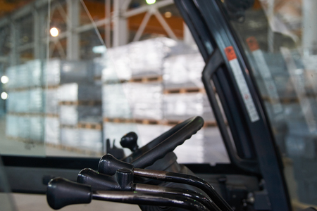 Cabin forklift truck with levers and steering wheel control in factory warehouse on backgroundの写真素材