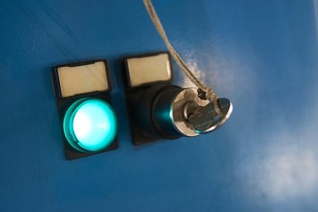Emergency stop button and key on control panel of industrial machine for safety at factory