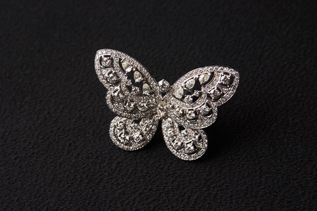 Beautiful butterfly shaped gold diamond ring or brooch. Luxury female jewellery, close-up. Selective focusの写真素材