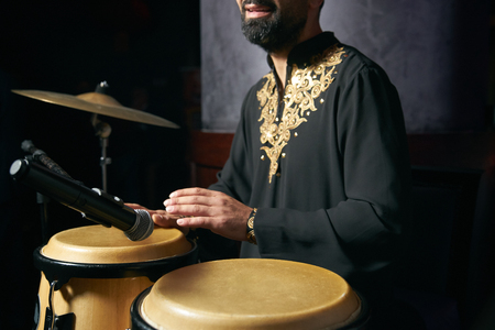 Man hands playing music at djembe drums. Musician playing congas, close-up. Rhythm of Africa, Bongo drum musicの写真素材