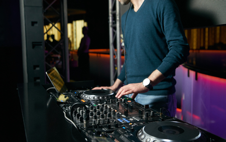 DJ with Turntables playing music at mixer. Dj mixing indoor at party festivalの写真素材