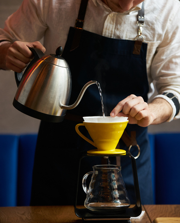 Bartender Hand drip coffee , Barista pouring water on coffee ground with paper filterの写真素材