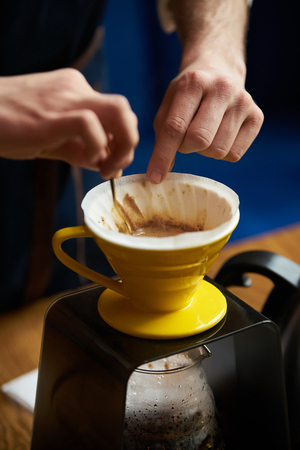 Bartender Hand drip coffee , Barista pouring water on coffee ground with paper filterの写真素材