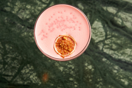 Classical Katana cocktail on table, close-up. Freshly cocktail with Rum, Passionfruit pure, Egg white, Sumax syrup, Ginger infuse. Sour-sweet, light, spicy alcoholic drinkの写真素材