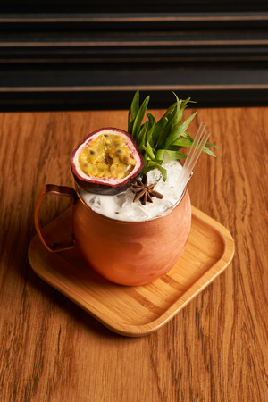 Spicy Mule cocktail on bar table. Alcoholic beverage drink with Rum angostura, reserve rum, dry orange passionfruit ,pure, pineapple pure, spice syrup ingredients, close-upの写真素材