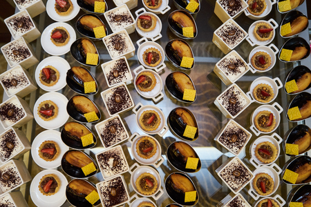 Various sweets snacks pudding yogurt souffle cookies with strawberries on a serving buffet table at restaurant, close-up.の写真素材
