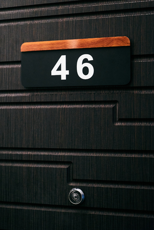 House number forty six 46 on brown wooden doorの写真素材