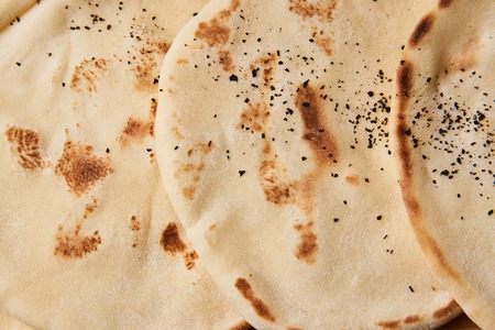 Pita bread background on wooden board table, close-up, top view. Can be used as background for cooking recipe or restaurant menu.の写真素材