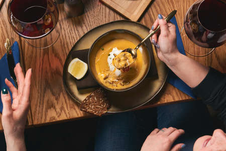 Table with food top view. People eat healthy meals at festive table served for party. Friends celebrate with organic food on wooden table view from above. Happy company having lunch, taking salad dishの写真素材