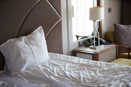 Elegant and comfortable home and hotel bedroom interior with single bed and desk lampの写真素材