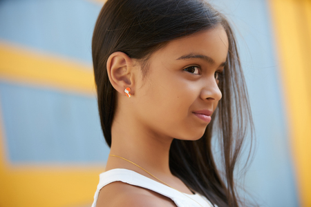 Beautiful young girl with bright smile and beautiful long hair. Portrait of a smiling pretty little girl, close-up, outdoorsの写真素材