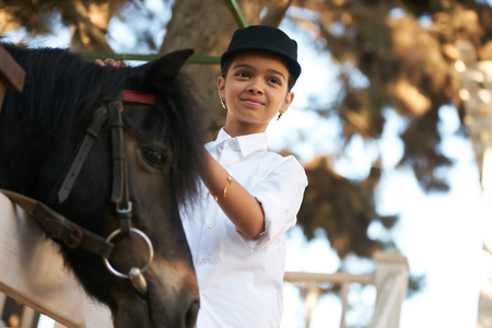 Portrait of young girl with horse. Young cute girl having fun with horseの写真素材