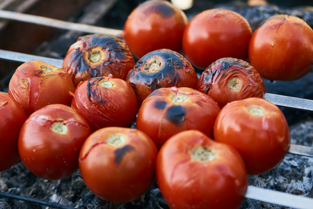 Tomatoes grilled on skewers, cooked outdoors. Grilled veggie skewers with cherry tomatoes. Healthy food conceptの写真素材