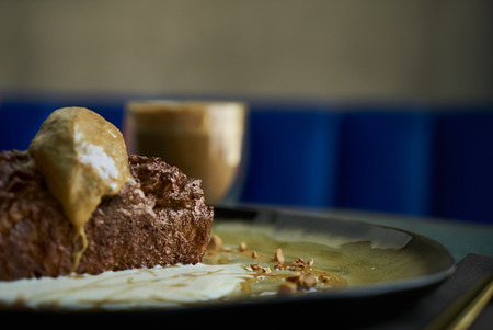Chocolate fondant lava cake with custard and pistachio ice cream, cocoa powder, mint leaves on...