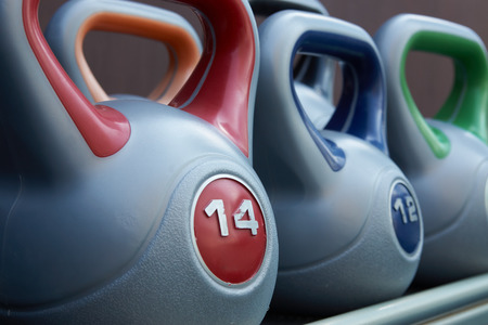 Colorful kettlebells weight on gym stand, background. Copy space. Fitness Sport equipmentの写真素材
