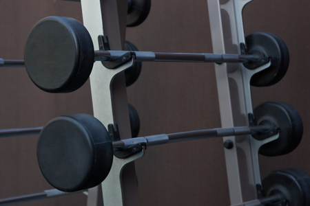 Sports equipment in gym. Barbells of different weight on standの写真素材