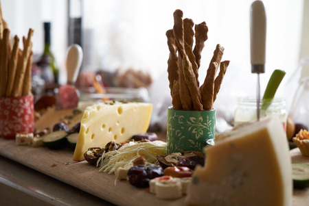 Snacks, fruits and drinks on table, indoors. House party concept. Festive table with food and various dishes, a fresh delicious lunch or beer snackの写真素材