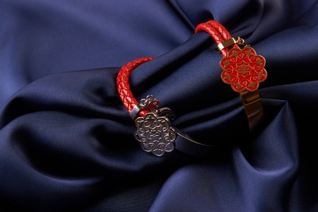 Pair of two Jewelery bijouterie rings with red leather on blue silk background with copy space, Beautiful precious womens jewelry, close-upの写真素材