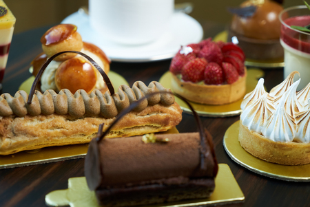 Breakfast time with cup of hot coffee and pieces of cream cake with strawberries and raspberries,...