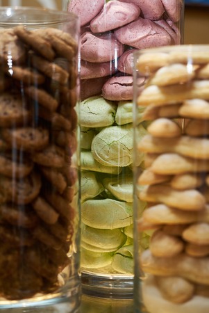 Glass jars filled with cookies snack, close-up. Dessert choice. Cookies and biscuits in glass jars on counter bar for sale. Dessert table at kids birthday party, Festive gatheringの写真素材