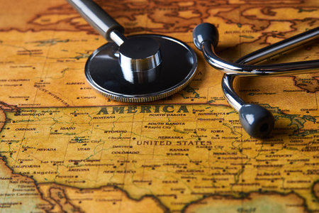 Medical stethoscope over America healthcheck. Medical concept tourism travel care diseases healthy, close-up. Stethoscope on map background with copy space, top view, selective focus.の写真素材