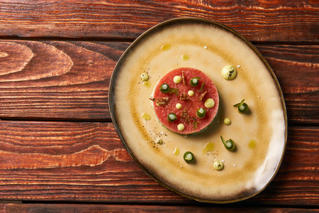 Classic tartare meat with ingredients on plate. Fresh Beef tartare Steak with egg yolk, pistachios, truffle oil, green mayonnaise.の写真素材