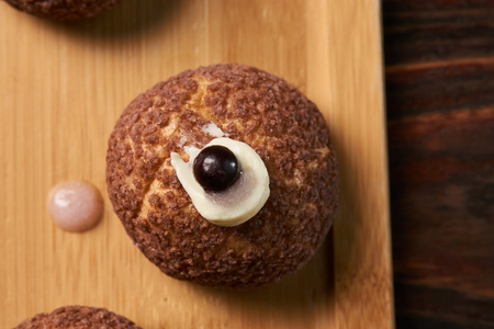 Brioche shu cake with cream chantilly, eclair. Chocolate profiteroles with peach violet.  Sweet...