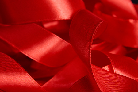 Red satin fabric ribbon as abstract romantic background. Beautiful shyny red silk ribbon texture...