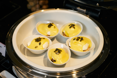 Eggs Benedict- English breakfast, close-up. Hotel restaurant buffet catering table with breakfast food, benedict egg in a white plate.の写真素材