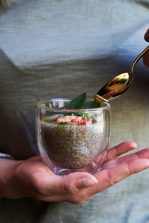 Spring seasonal smoothie drink detox. Woman hands holding glass with green smoothie or juice. Healthy breakfast conceptの写真素材