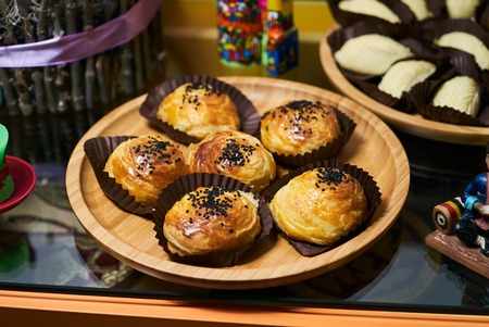 Novruz traditional Azerbaijan pastry Shekerbura and salty gogal on wooden plate background, top...