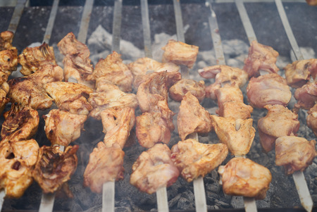 Roasted chicken wings kebab on skewers, close-up, outdoors